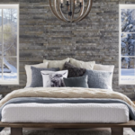 Cozy bedroom with layered bedding and textured wood wall.